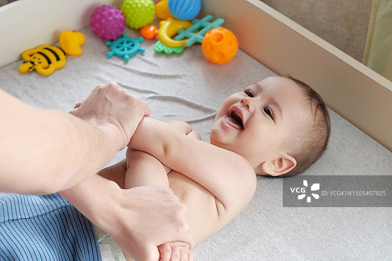 母亲为健康的宝宝按摩。有爱心的女人为小宝宝做体操图片素材