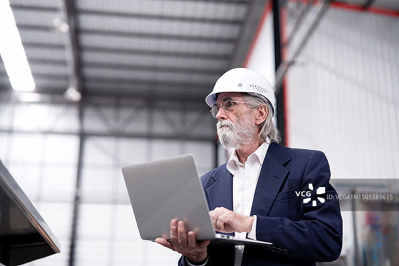 金融规划与分析：制造业成本与收入分析，企业主用笔记本电脑监控生产线图片素材