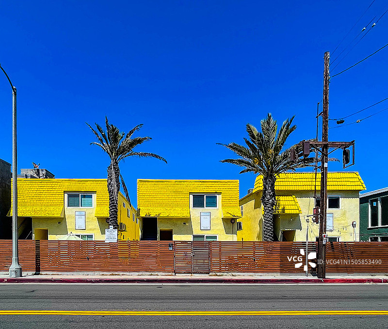 威尼斯，加利福尼亚州的三栋黄色瓦片屋顶房子图片素材
