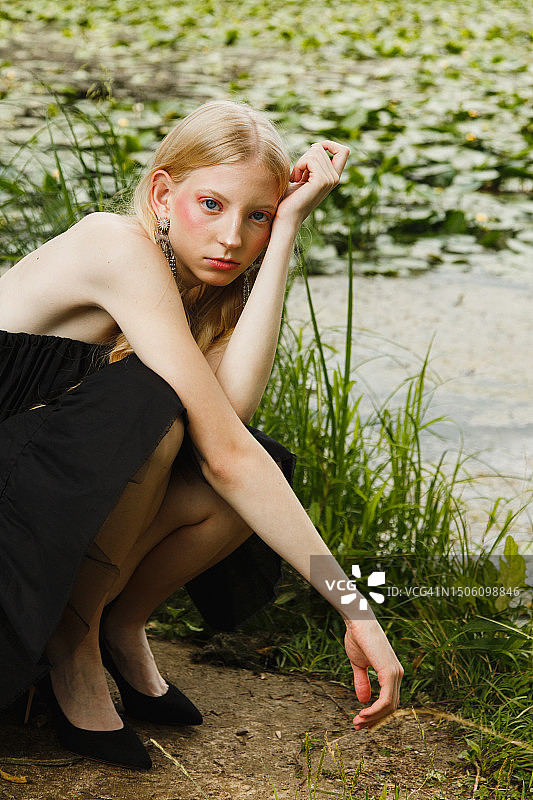 湖边蹲着的年轻女子肖像图片素材