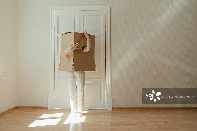 站在家中的硬木地板上手捧盒子的女人图片素材