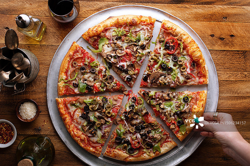 高角度拍摄：女人手拿一片披萨图片素材