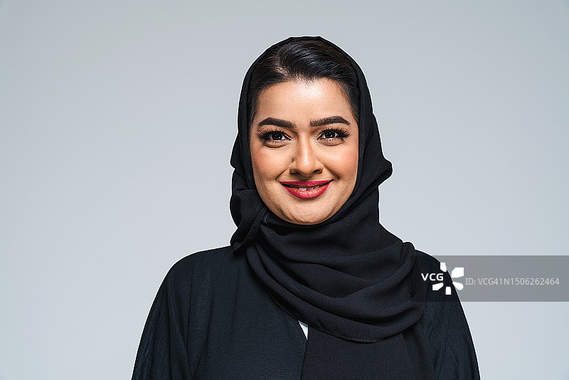 戴头巾的微笑年轻女子肖像，灰色背景图片素材
