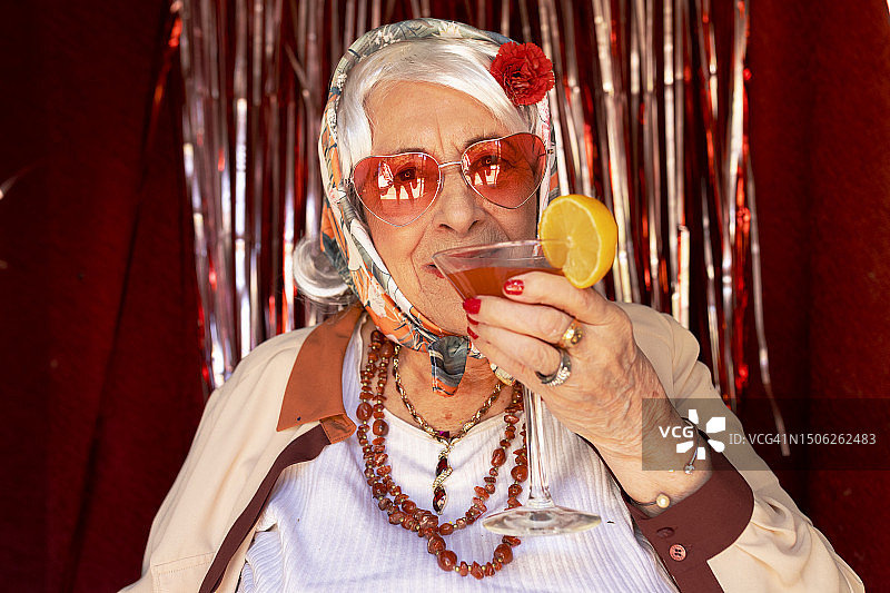 奶奶穿着复古服装喝酒精鸡尾酒图片素材
