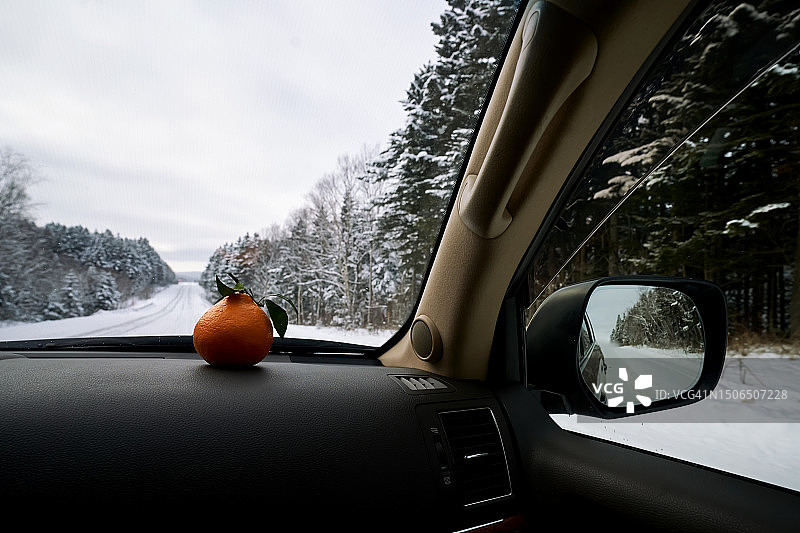雪路景观：挡风玻璃前的橘子图片素材