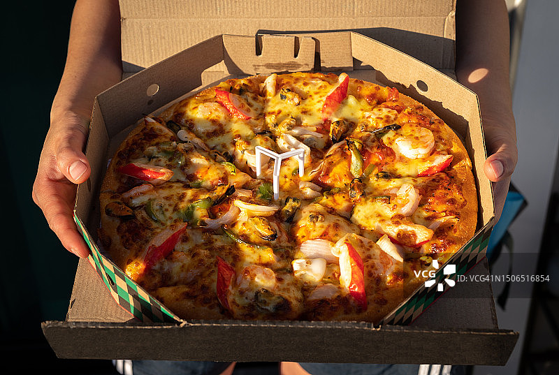 手持海鲜豪华披萨图片素材