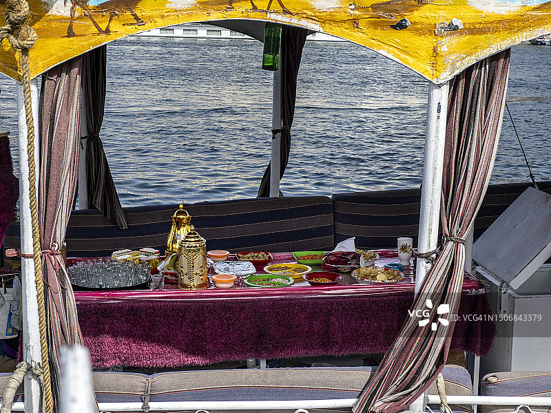 尼罗河上的三角帆船，为游客准备了食物的餐桌图片素材