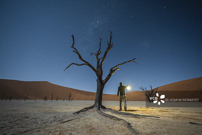 男人在夜晚打着灯笼探索沙漠图片素材