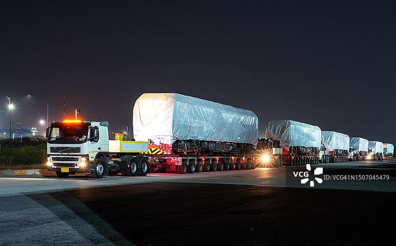 重型超大货车将新机车装载到港口区域的铁轨上图片素材