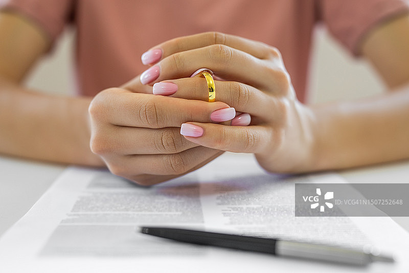 女人摘下结婚戒指图片素材