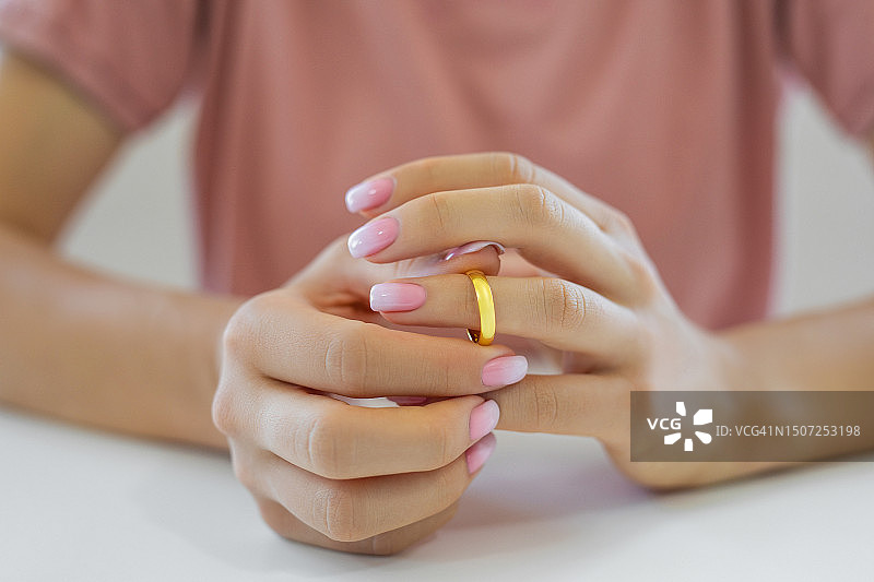 女人摘下结婚戒指图片素材