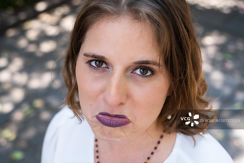 失望地抬头看着镜头，撅着下唇，像个孩子一样要哭的女人图片素材