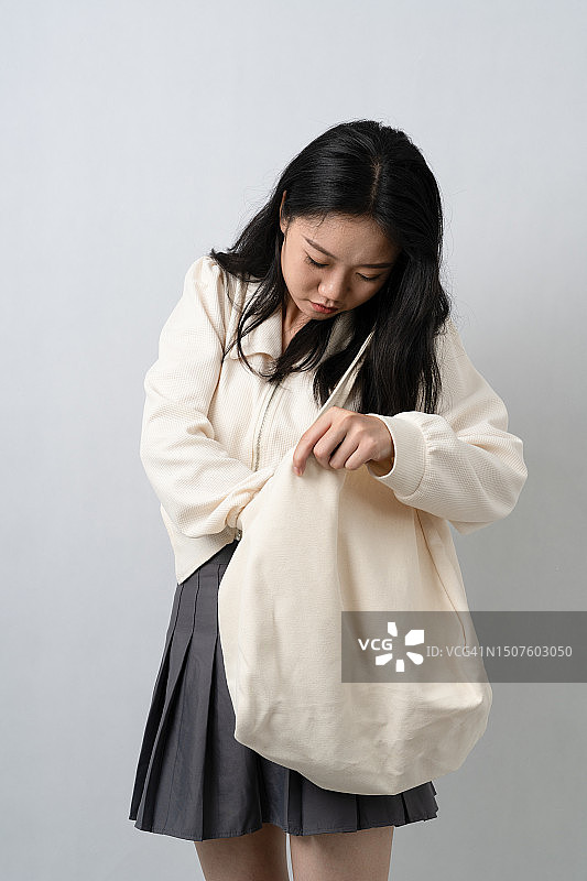 年轻女人在包里找东西图片素材