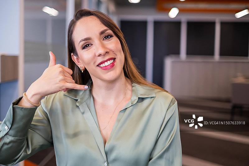 做“打电话给我”手势的拉丁裔女人图片素材