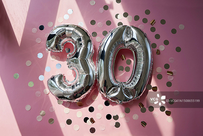 阳光粉色背景下的银色30周年气球图片素材