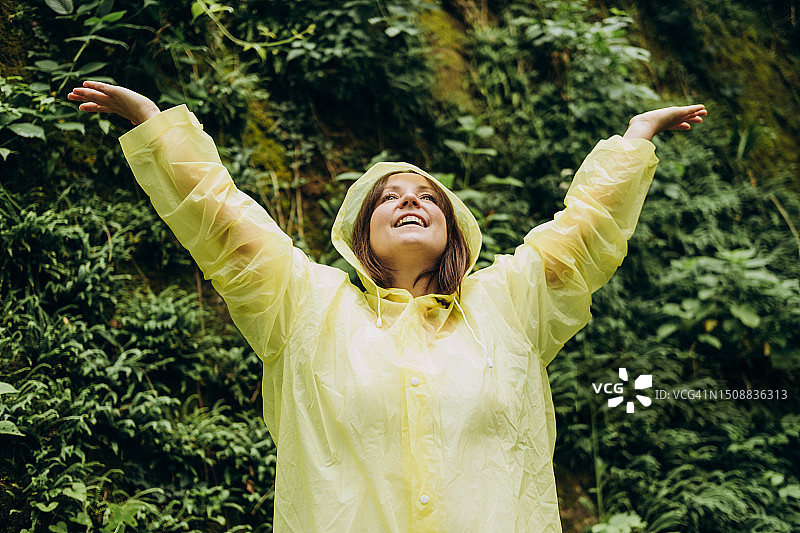 穿着黄色雨衣的快乐女人图片素材