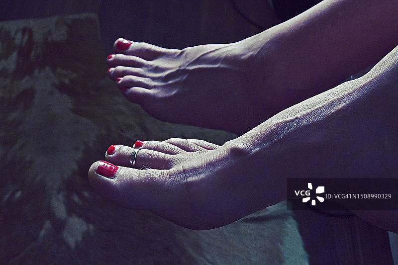 一双女人的脚悬在床边图片素材