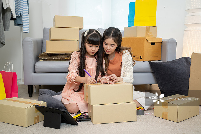 年轻亚洲女性在家使用平板电脑进行网上购物图片素材