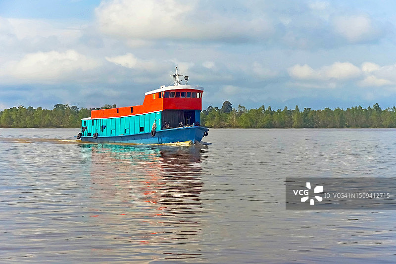 在马来西亚沙捞越诗巫的拉让江上行驶的彩色驳船图片素材