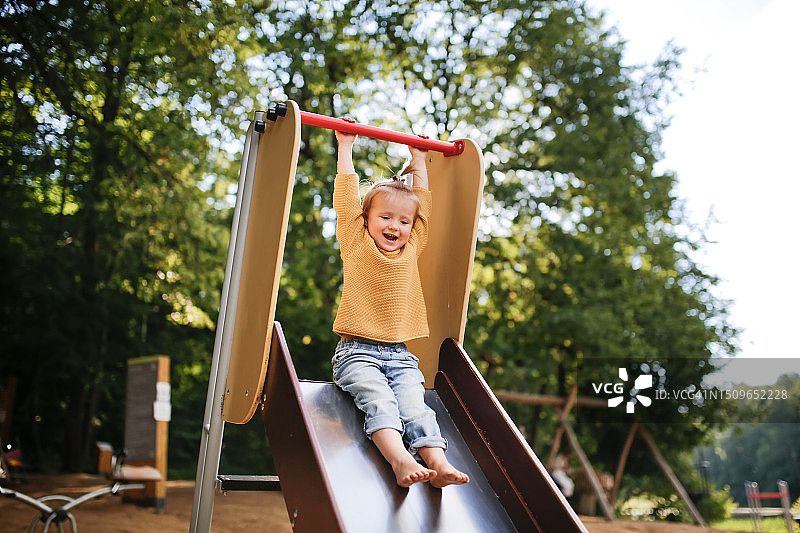 阳光明媚的滑梯：快乐的幼儿体验在操场上滑下来的乐趣图片素材