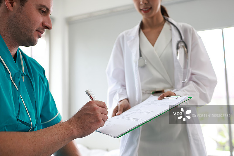 男病人在医院与女医生签署文件图片素材