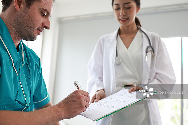 男病人在医院与女医生签署文件图片素材