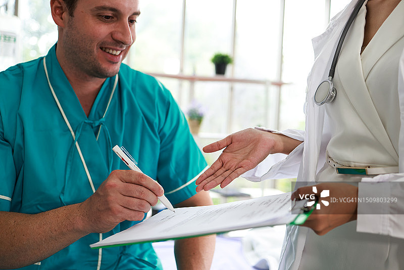男病人在医院与女医生签署文件图片素材