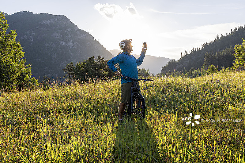 山地自行车手在山地草甸中拍照图片素材