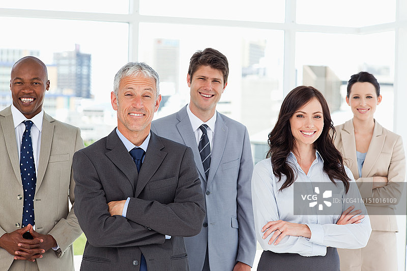 五位商务人士在明亮的窗前交叉双臂图片素材