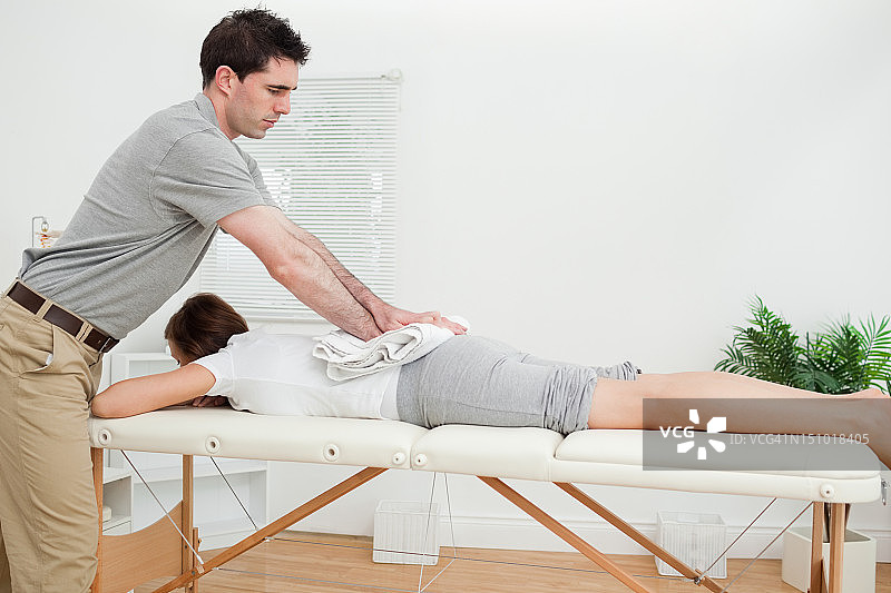 女人躺着享受毛巾按摩图片素材