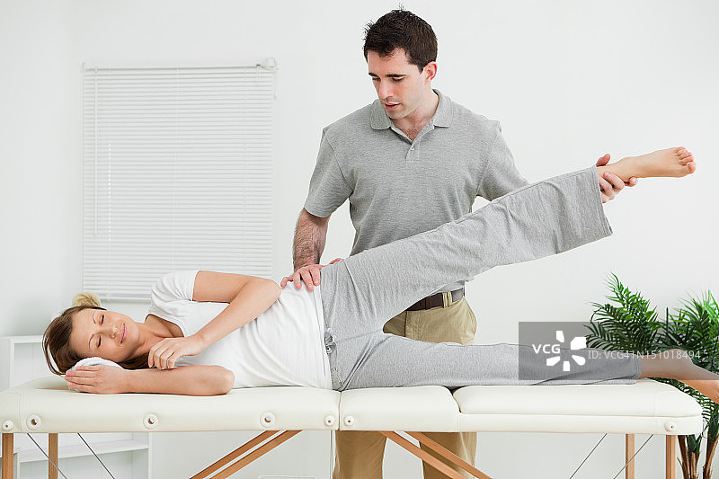 从业者抬起病人的腿图片素材