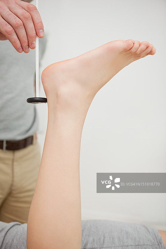 医生检查病人的踝关节反射图片素材