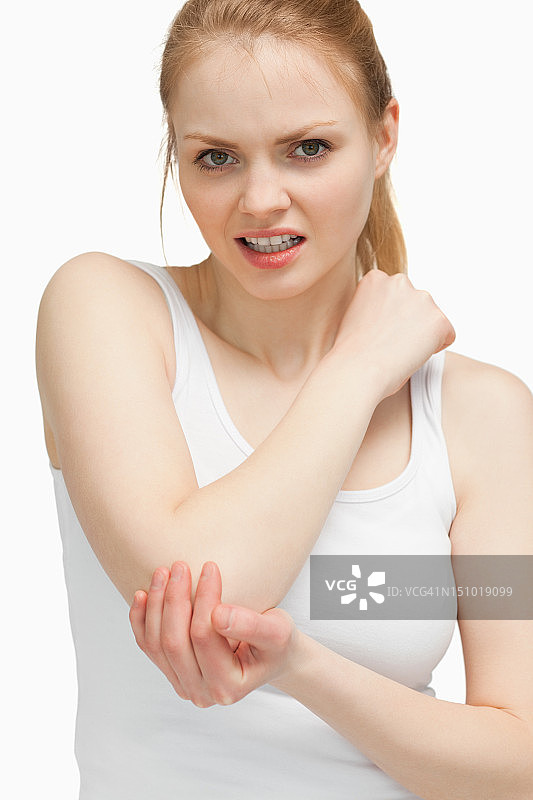 触摸疼痛手肘的金发女人图片素材