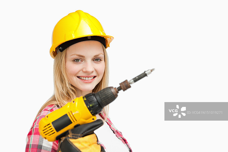 拿着电动螺丝刀微笑的女人图片素材