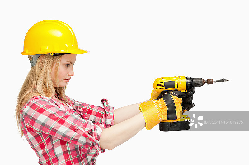 使用电动螺丝刀的严肃女人图片素材