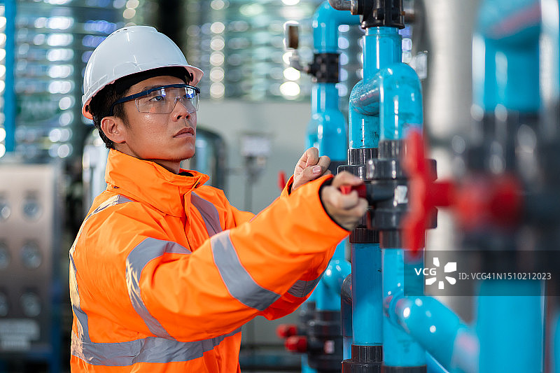 亚洲技术工程师维护饮用水管道和压力罐。图片素材