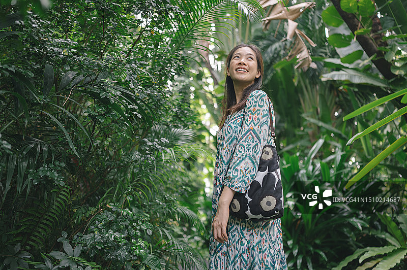 具有可持续生活方式的亚洲Z世代选择环保和可重复使用的布料以及手提袋，并与她最喜欢的绿色花园合影图片素材