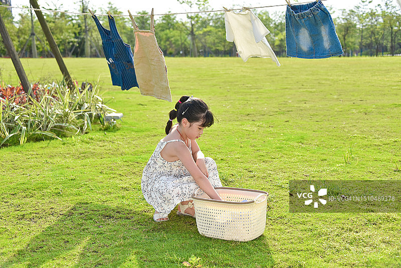 欢乐时光：在公园里晾衣服的亚洲小女孩（6-7岁），中国广东省江门市图片素材