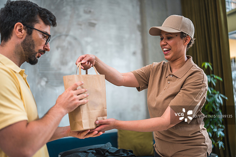 多种族女人为年轻上班族送新鲜餐食图片素材
