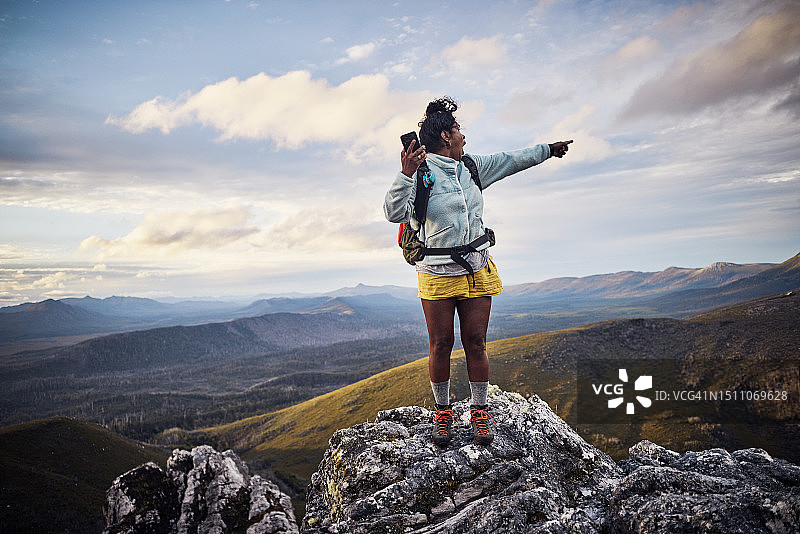 在澳大利亚塔斯马尼亚偏远山区寻找手机信号的徒步女性图片素材