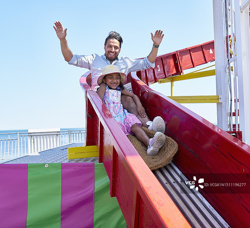 父女在假日乘坐螺旋滑梯图片素材