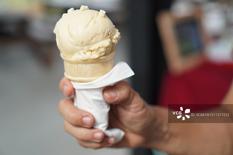 女人手中的芒果冰淇淋甜筒图片素材
