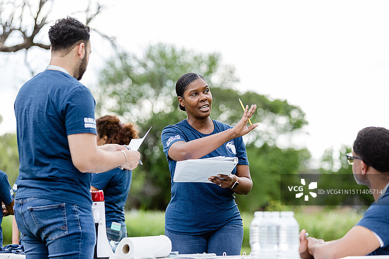 女领队在讲解志愿者活动的场地布置图片素材