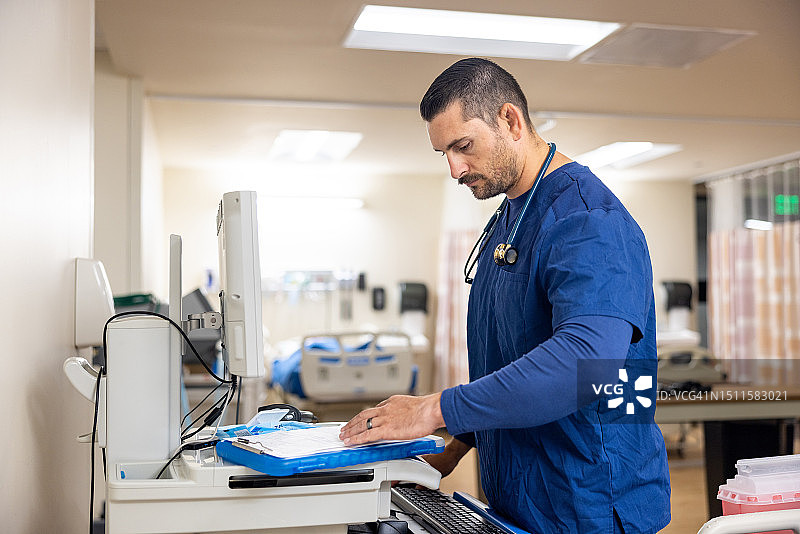 在医院站立式办公桌前使用电脑的男护士图片素材