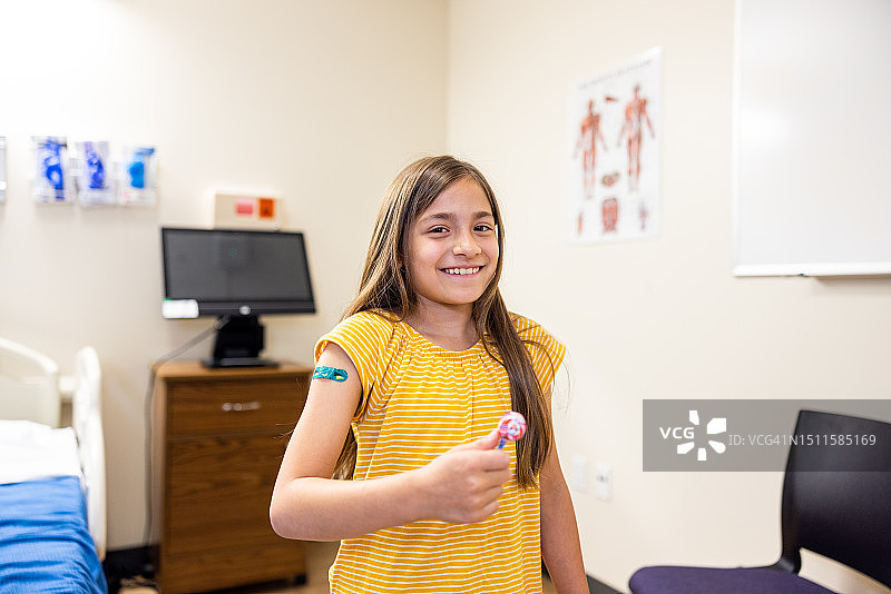 在医生预约后拿着棒棒糖的小女孩图片素材