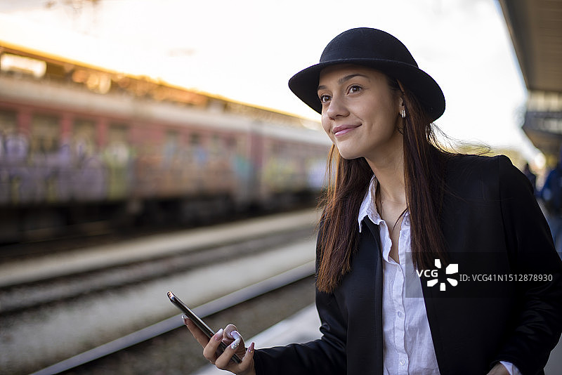 用手机查看列车时刻表的迷人女性图片素材