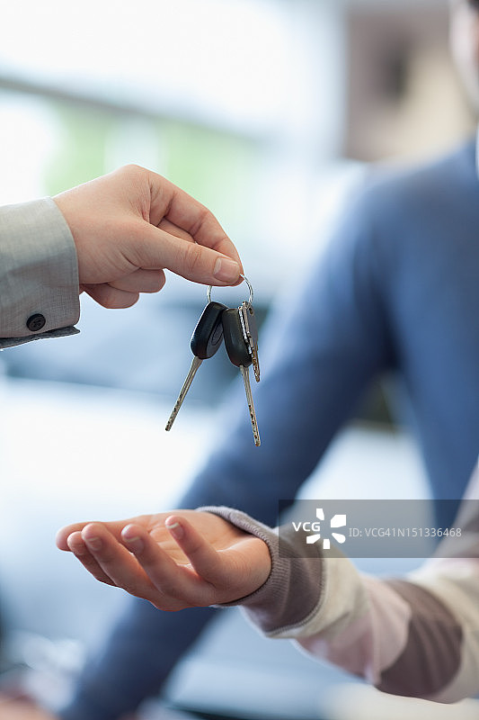 销售员将钥匙放在顾客的手上图片素材