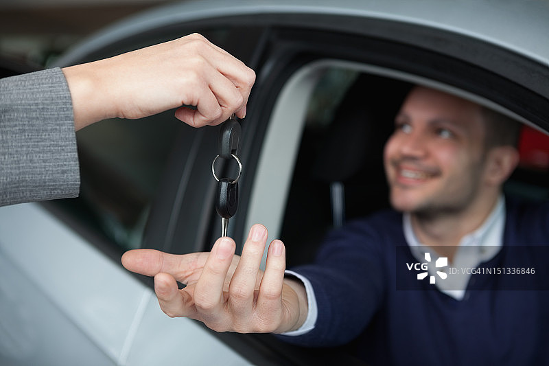 男子坐在车里接过车钥匙图片素材