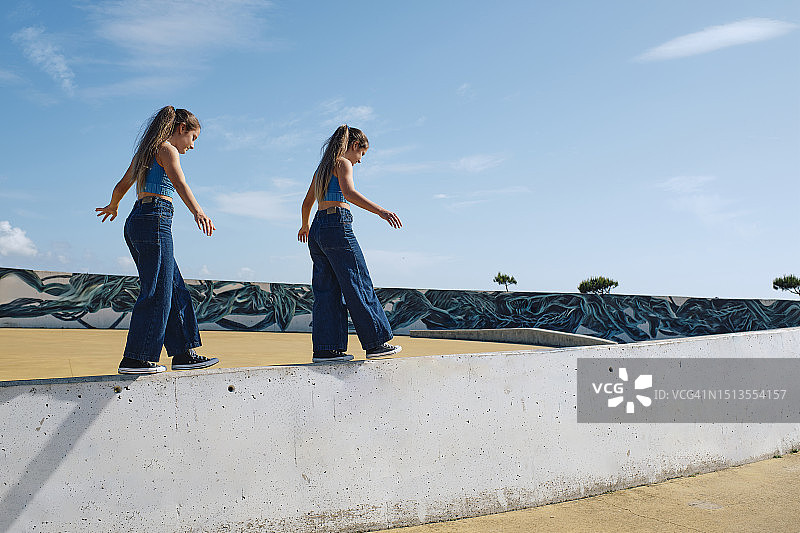 在滑板公园墙上行走的女孩们图片素材