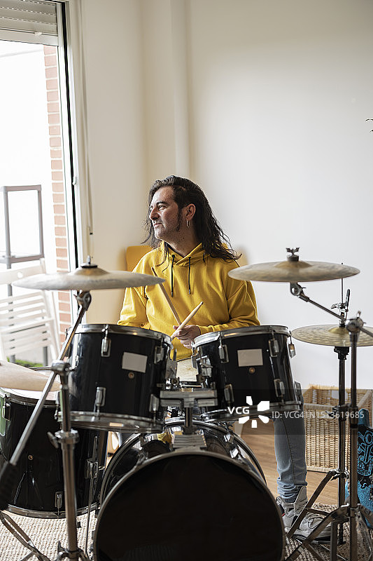 微笑的音乐家在家坐着打鼓图片素材